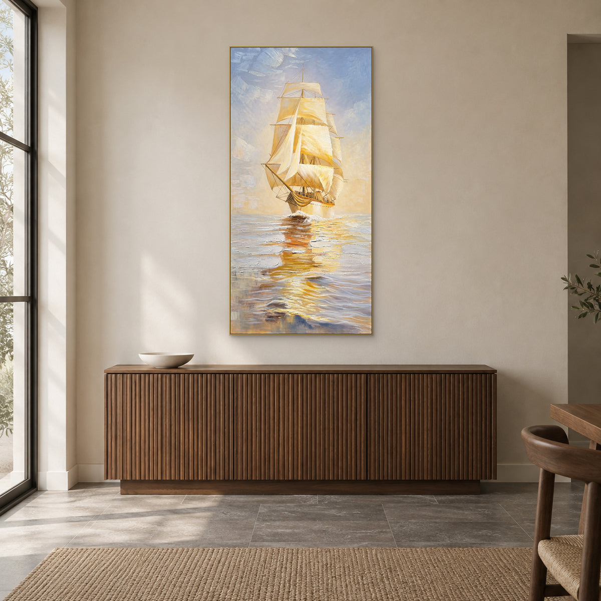 Tableau de voilier doré dans un cadre flottant champagne, au-dessus d’un buffet cannelé ton noyer.