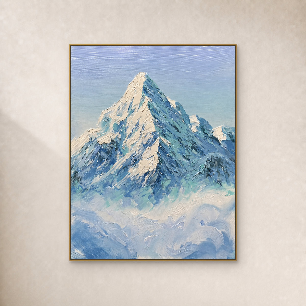 Sommet enneigé ivoire et crêtes bleu-vert au-dessus des nuages, dans un cadre doré fin sur un mur ivoire.