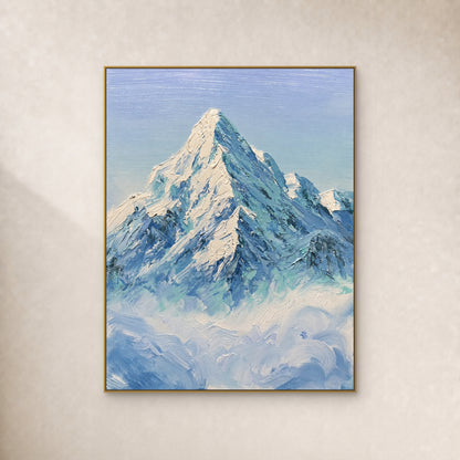 Sommet enneigé ivoire et crêtes bleu-vert au-dessus des nuages, dans un cadre doré fin sur un mur ivoire.