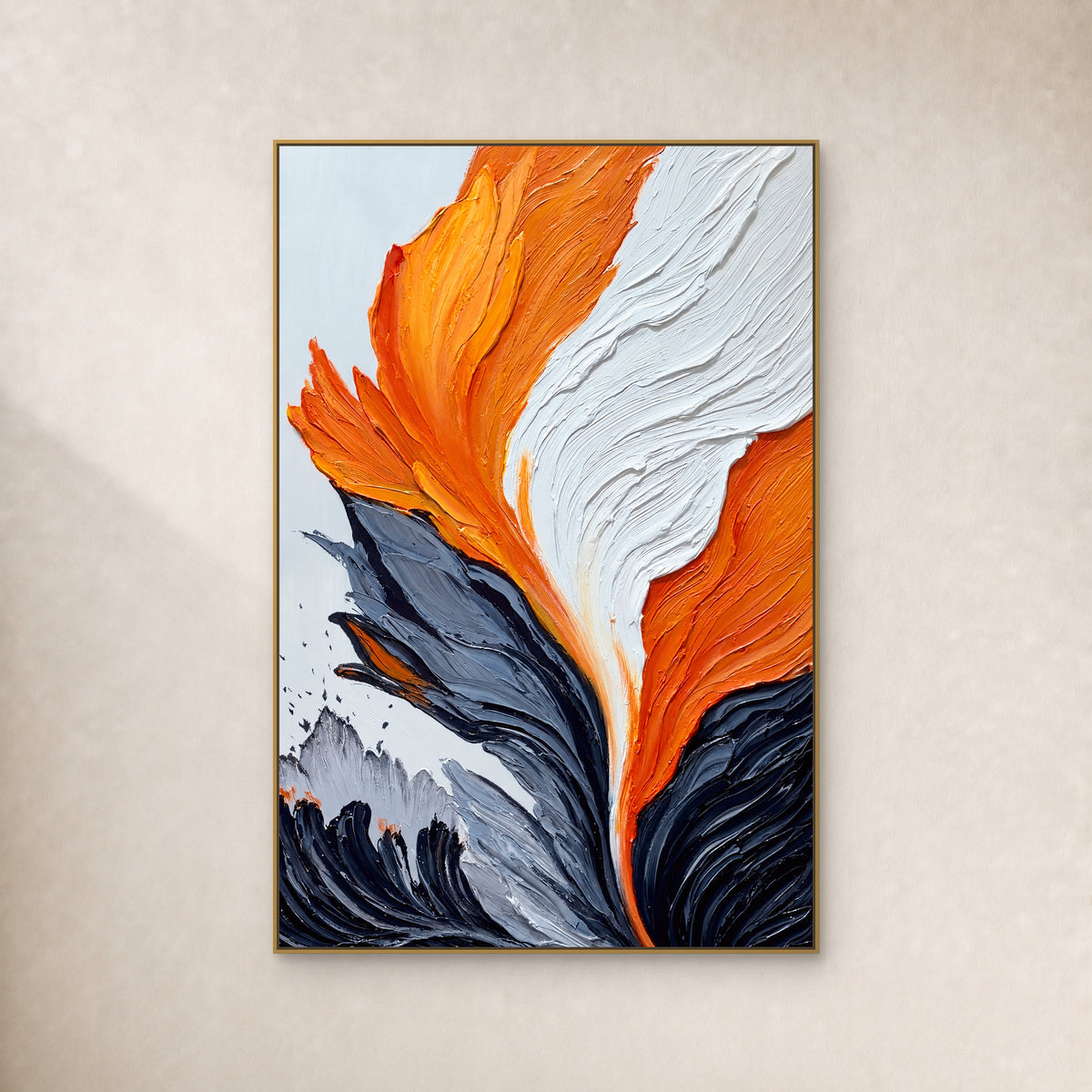 Tableau abstrait orange, blanc et noir charbon aux reliefs marqués, dans un fin cadre flottant doré sur un mur ivoire