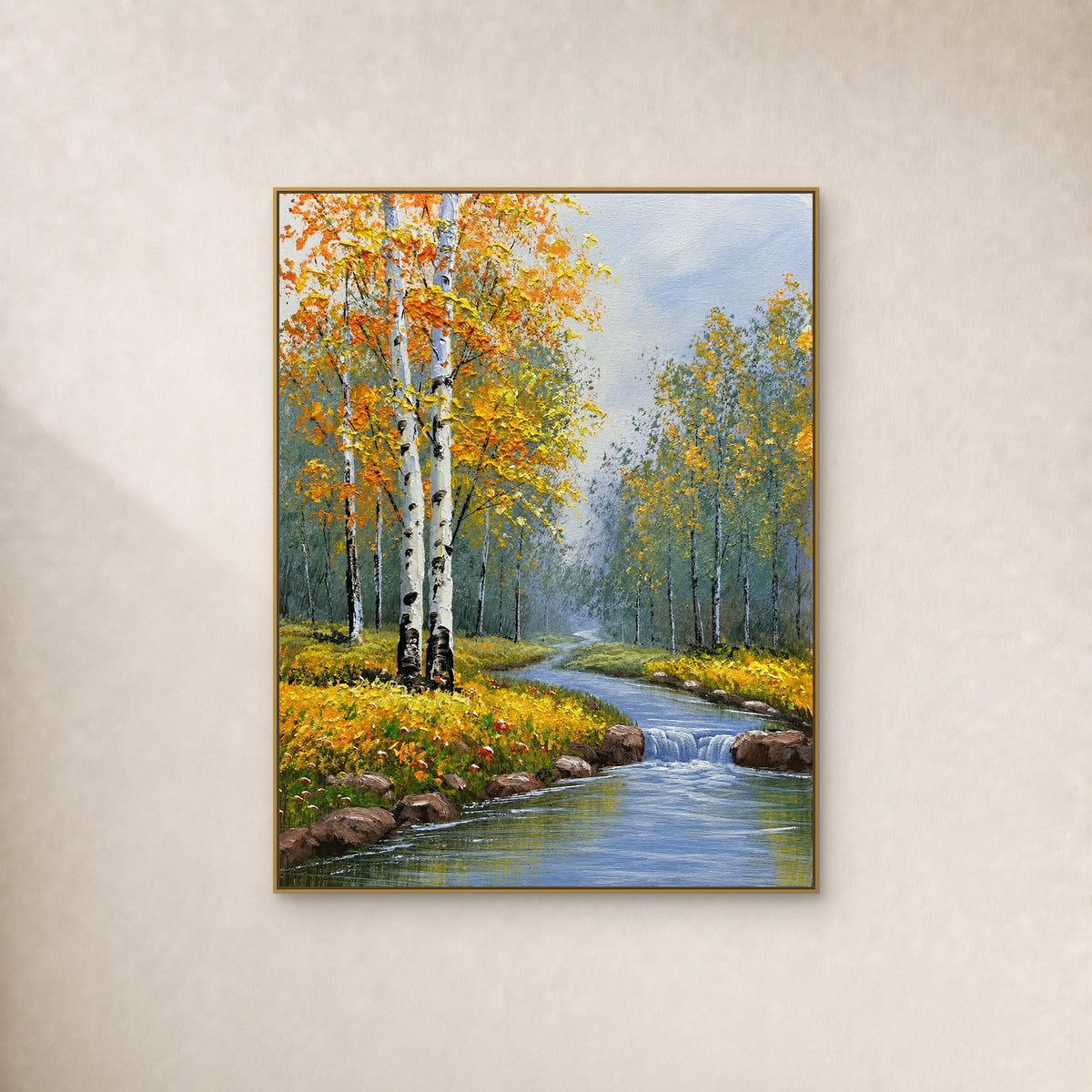 Bouleaux dorés et ruisseau bleu avec petite cascade, dans un fin cadre doré sur un mur ivoire.