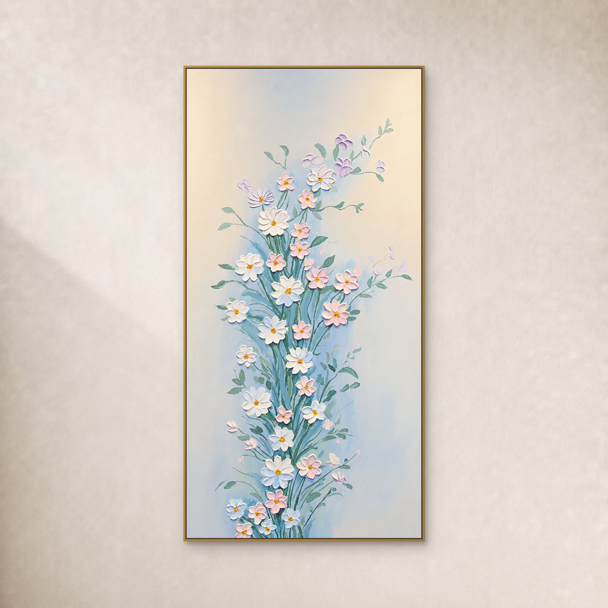 Tableau vertical de fleurs blanches et roses aux tiges vertes, dans un fin cadre doré sur un mur ivoire