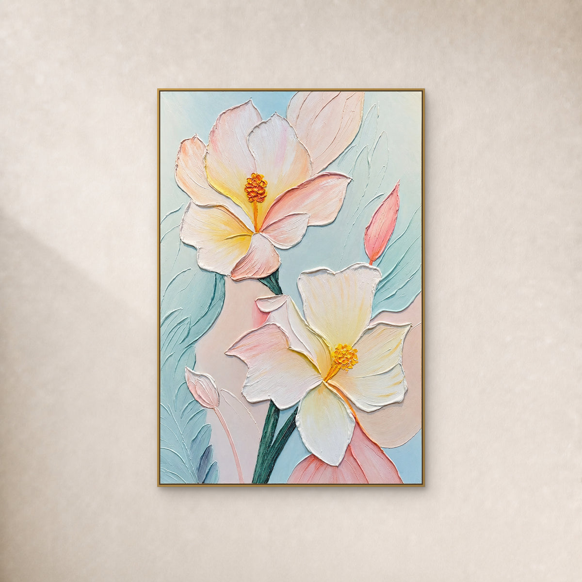 Deux fleurs crème et rose poudré aux cœurs jaunes en relief sur fond bleu d’eau, dans un fin cadre doré sur un mur ivoire