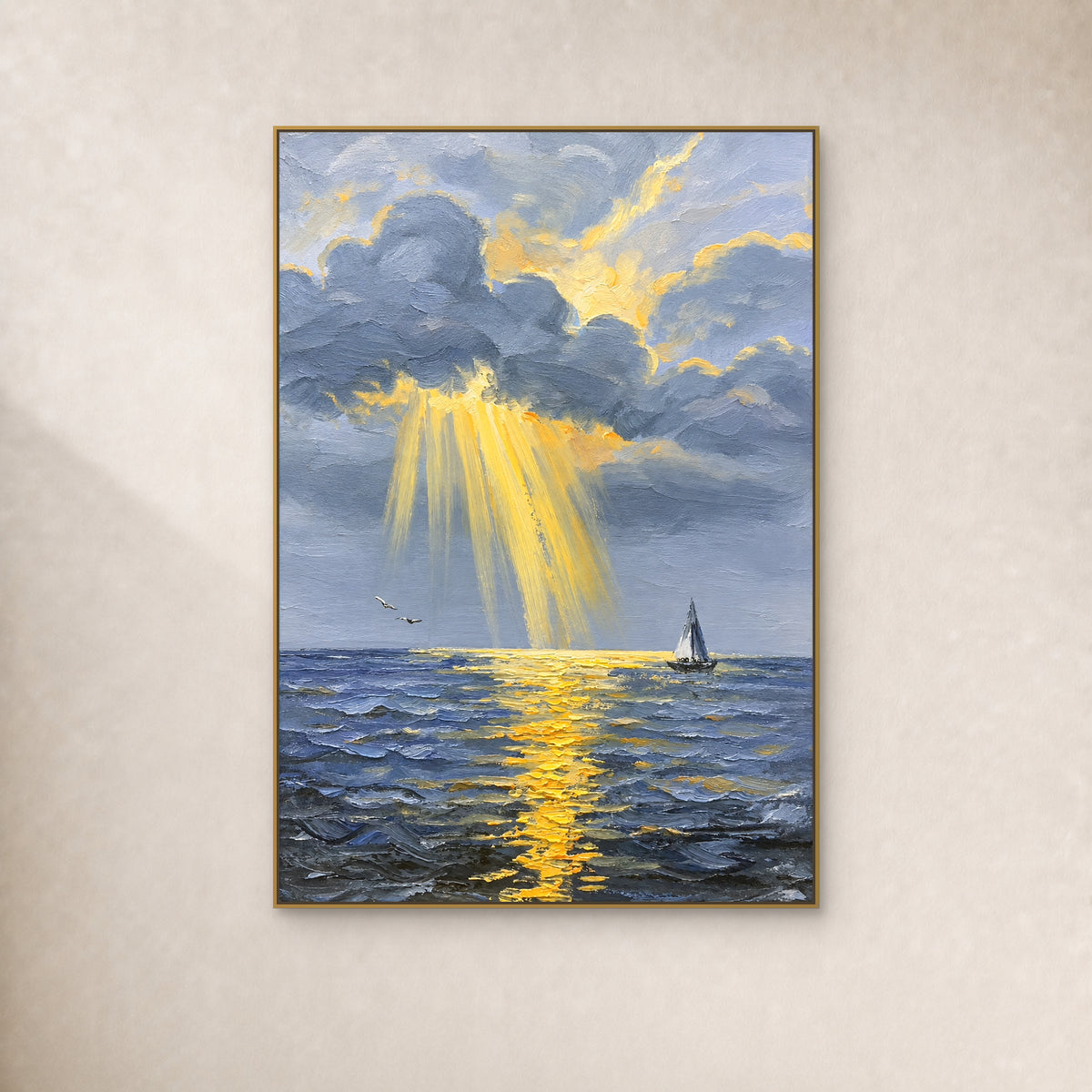 Golden rays breaking through blue-grey clouds over the sea, with a small sailboat, shown in a slim gold frame on an ivory wall.