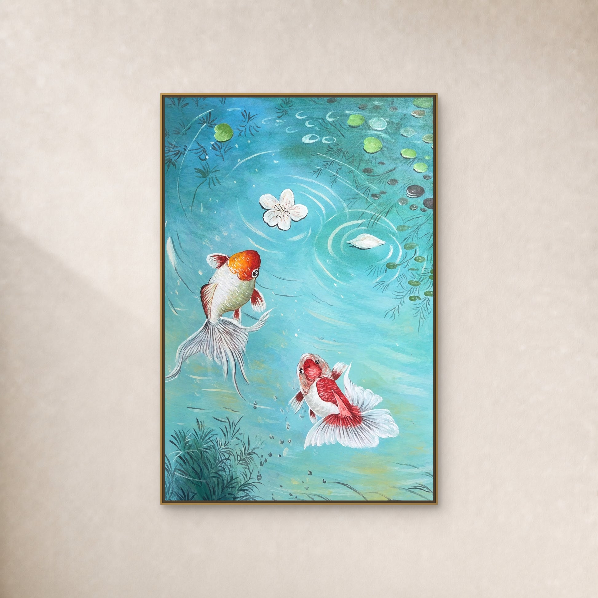Two long-tailed goldfish in turquoise water, in a slim gold floating frame on a warm ivory wall