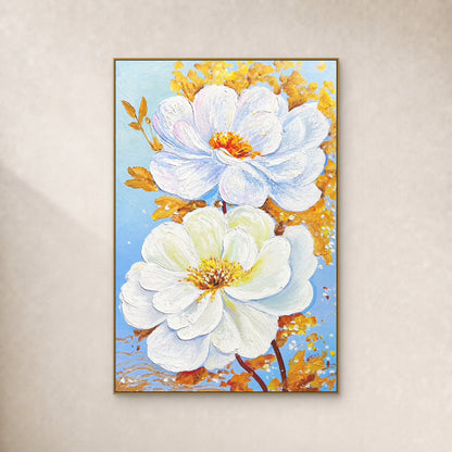 Two white blossoms with gold-coloured leaves on pale blue, shown in a slim gold-coloured floating frame on an ivory wall.