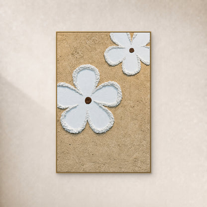 Two large white flowers with brown centres on a beige ground, in a slim gold-coloured frame on an ivory wall