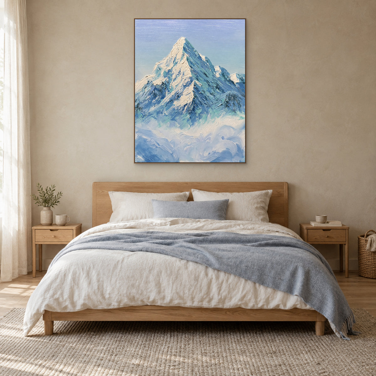 Tableau de montagne enneigée bleu-vert dans un cadre aspect chêne, centré au-dessus d’un lit à tête en bois clair.