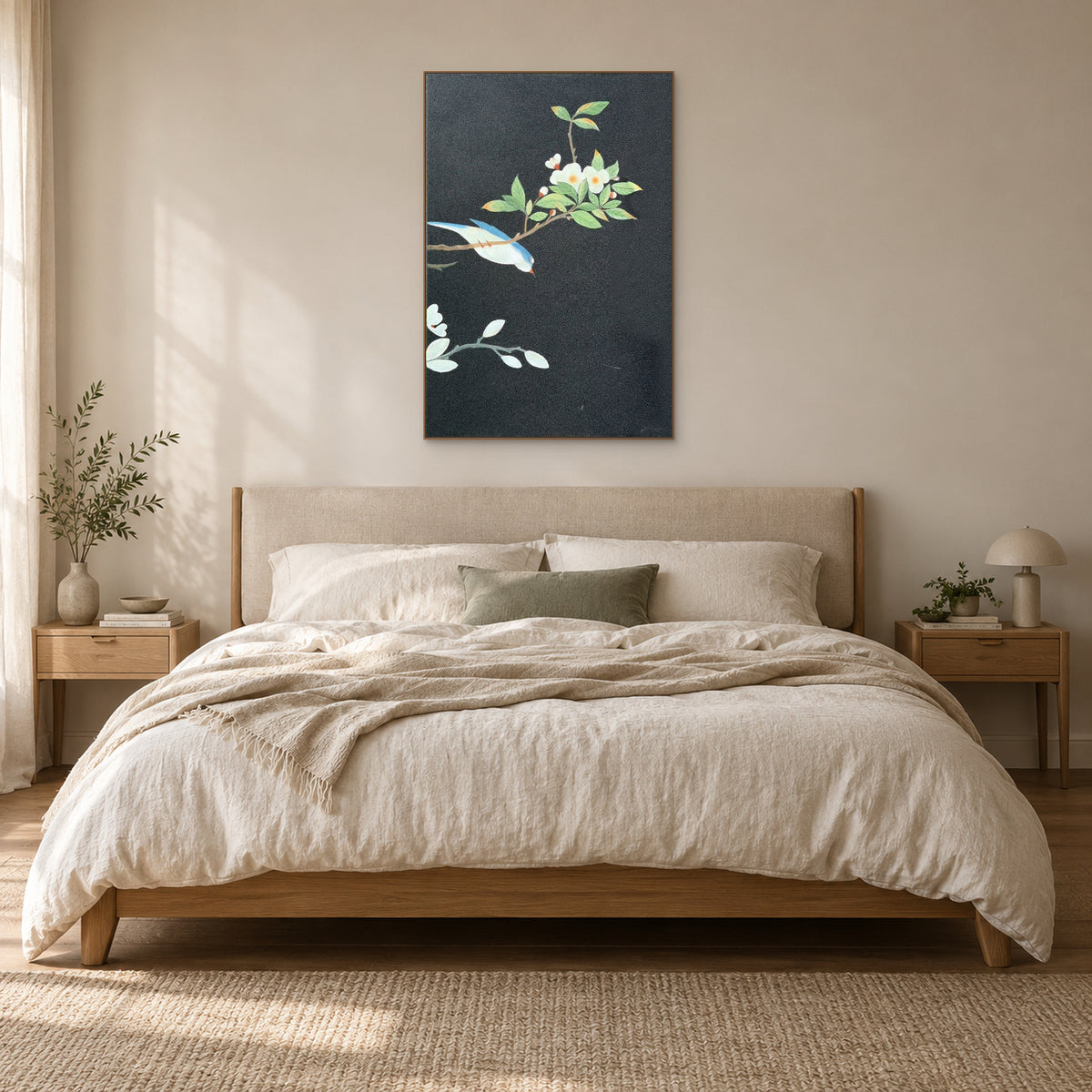 Bird and white blossom painting in an oak-tone frame above a cream upholstered headboard