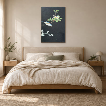 Bird and white blossom painting in an oak-tone frame above a cream upholstered headboard