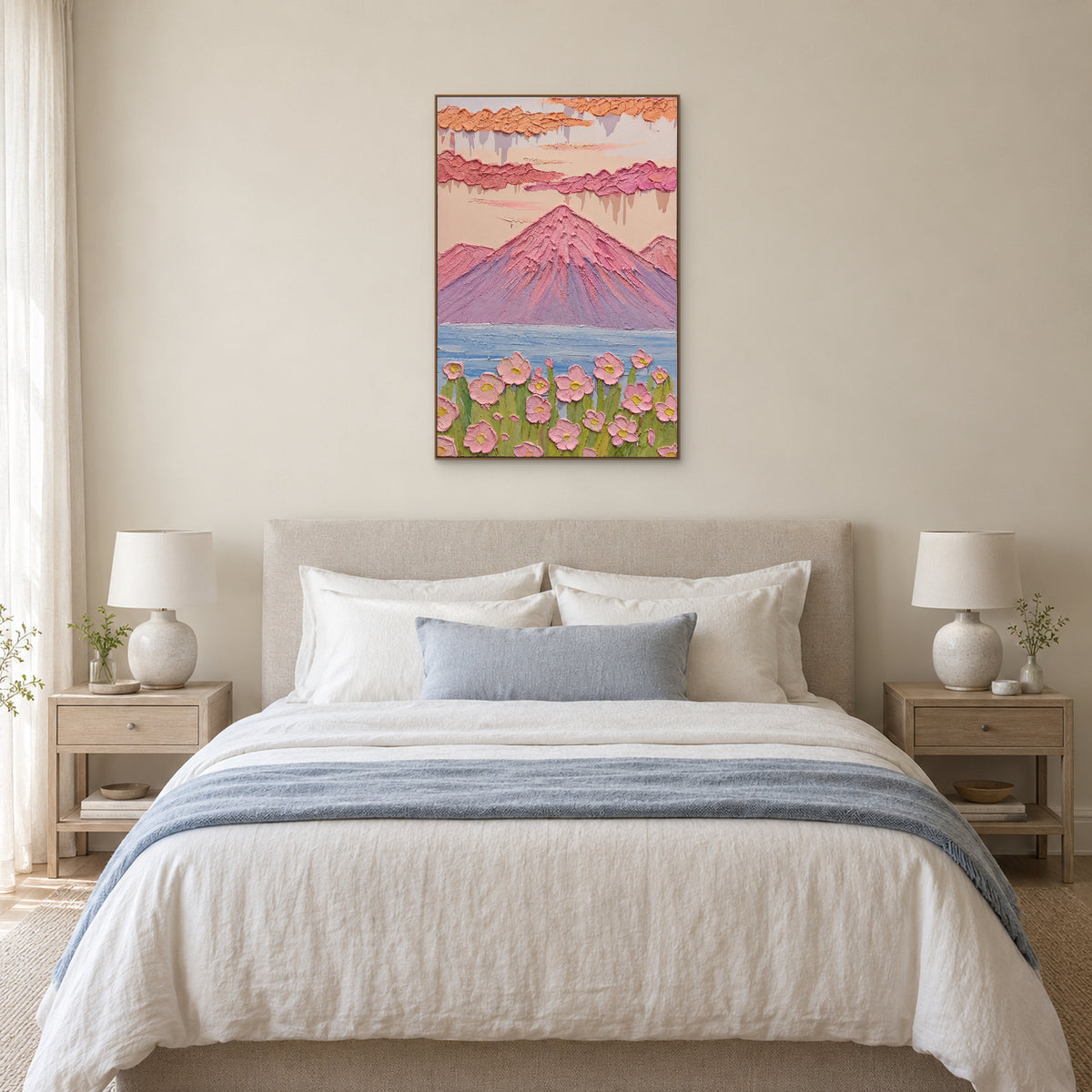 Tableau de montagne pastel et fleurs, dans un cadre ton chêne centré au-dessus d’une tête de lit en tissu