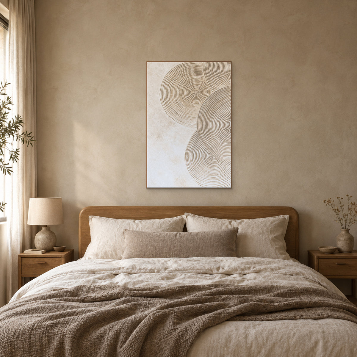 Ivory and sand circle relief in an oak-look frame, centred above a wooden headboard and cream linen bedding.