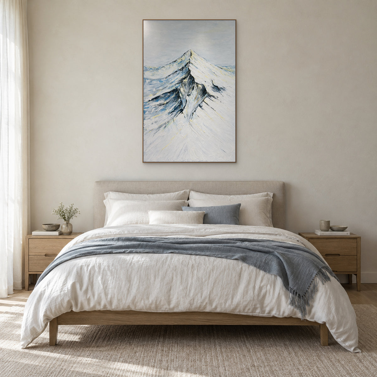 Vertical snowy mountain art in an oak-tone frame centred above a linen bed