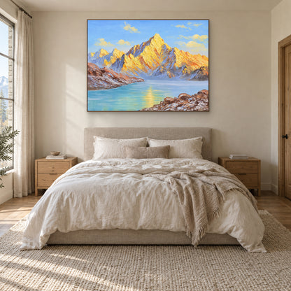 Tableau de lac bleu et de montagnes dorées, dans un cadre ton chêne centré au-dessus d'un lit crème