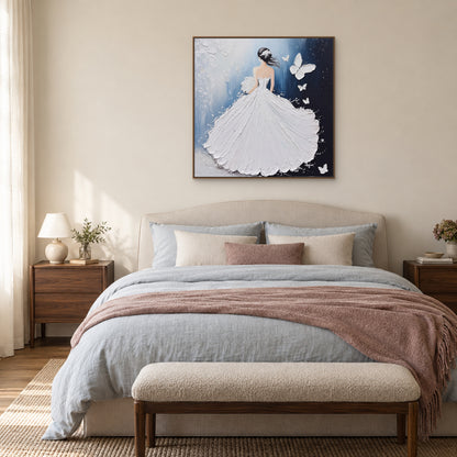White gown and butterfly painting in a light wood-tone frame, centred above an upholstered bed with soft blue bedding