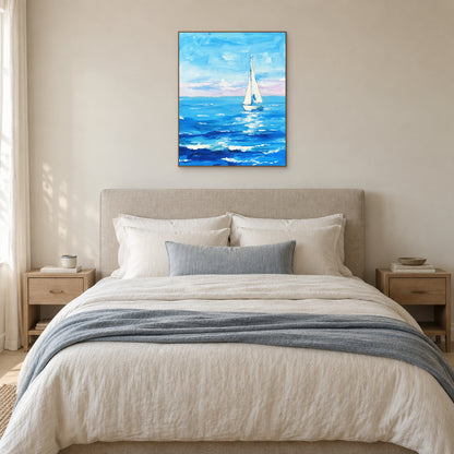 Blue sea and white sailboat painting in an oak-look frame centred above a cream upholstered bed.