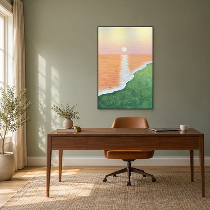 Vertical apricot seascape in a black frame above a walnut desk and caramel chair against a sage wall