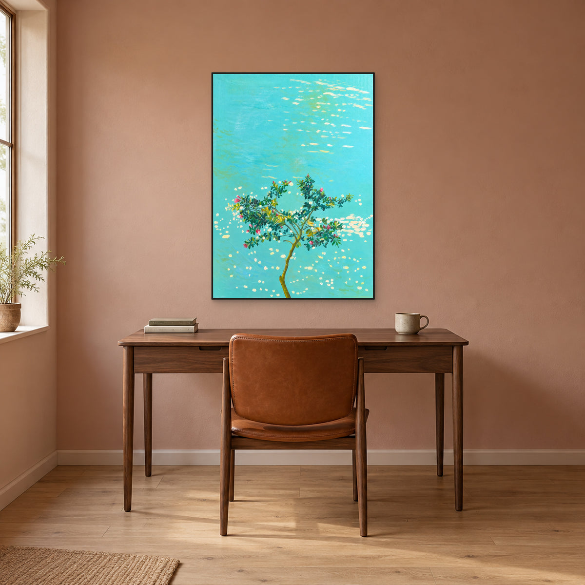 Tableau d’arbre fleuri dans un cadre flottant noir fin au-dessus d’un bureau ton noyer, sur un mur terre cuite