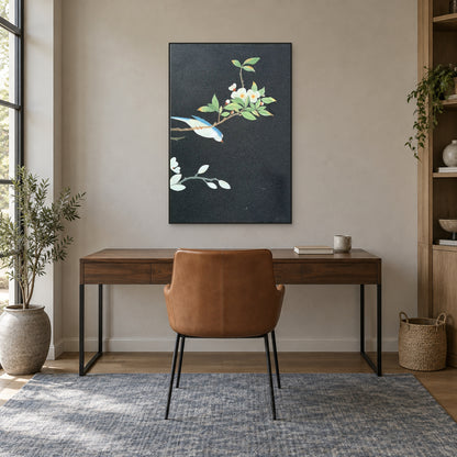 Black-framed blue bird painting centred above a walnut-tone desk and caramel chair