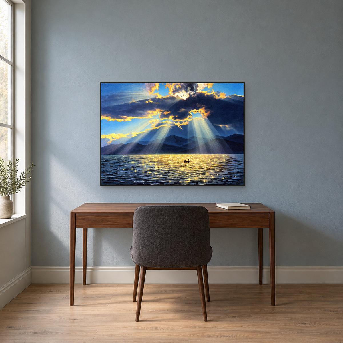 Blue lake and golden sunbeams in a thin black frame above a walnut desk against a blue-grey wall