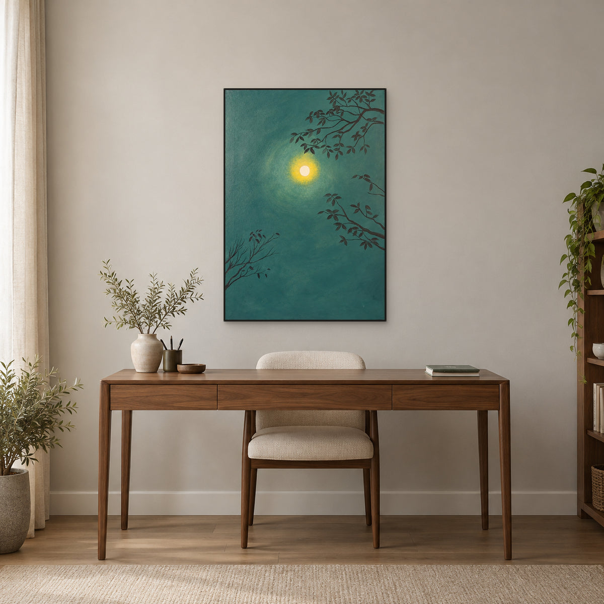 Green moon painting in a thin black floating frame above a walnut-toned desk