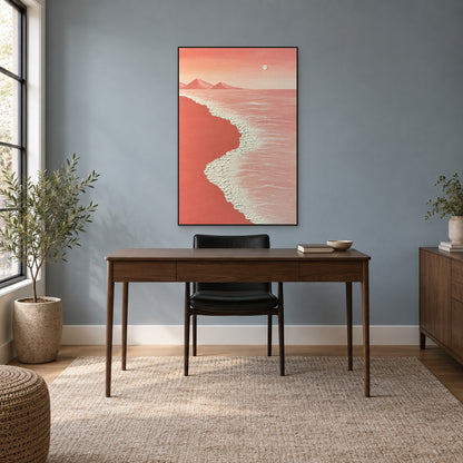 Pink beach artwork in a thin black floating frame above a walnut-toned desk against a blue-grey wall