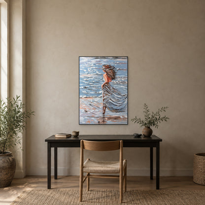 Femme en robe au vent dans un cadre flottant noir, au-dessus d'un bureau sombre et d'une chaise en bois à assise tressée devant un mur taupe