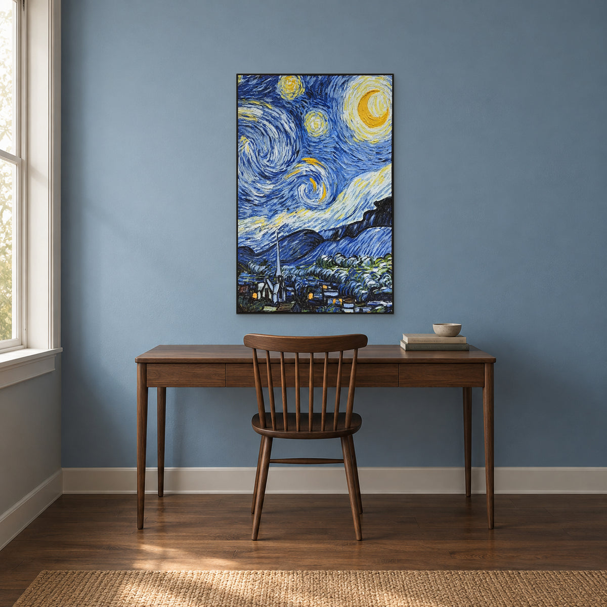 Croissant de lune et ciel bleu tourbillonnant dans un cadre noir, au-dessus d’un bureau en noyer contre un mur bleu assourdi.