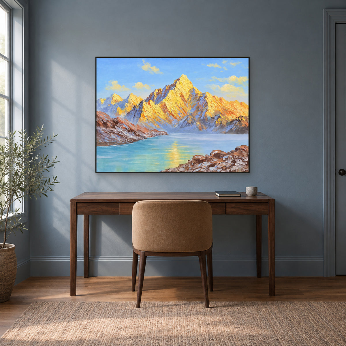 Sommets dorés et lac turquoise dans un cadre noir fin, au-dessus d'un bureau couleur noyer sur un mur bleu-gris