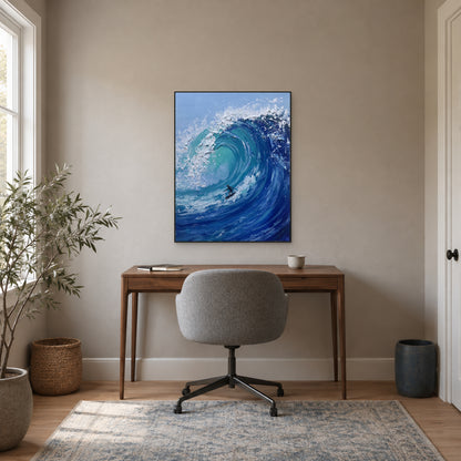 Black-framed turquoise surfing artwork above a wooden desk with a grey office chair