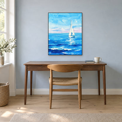 White sailboat painting in a thin black frame above a wooden desk against a mist-blue wall.