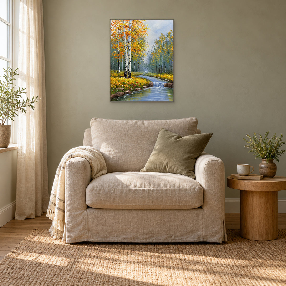 Feuillage doré de bouleaux et ruisseau bleu dans la brume, cadre blanc au-dessus d’un fauteuil couleur lin.