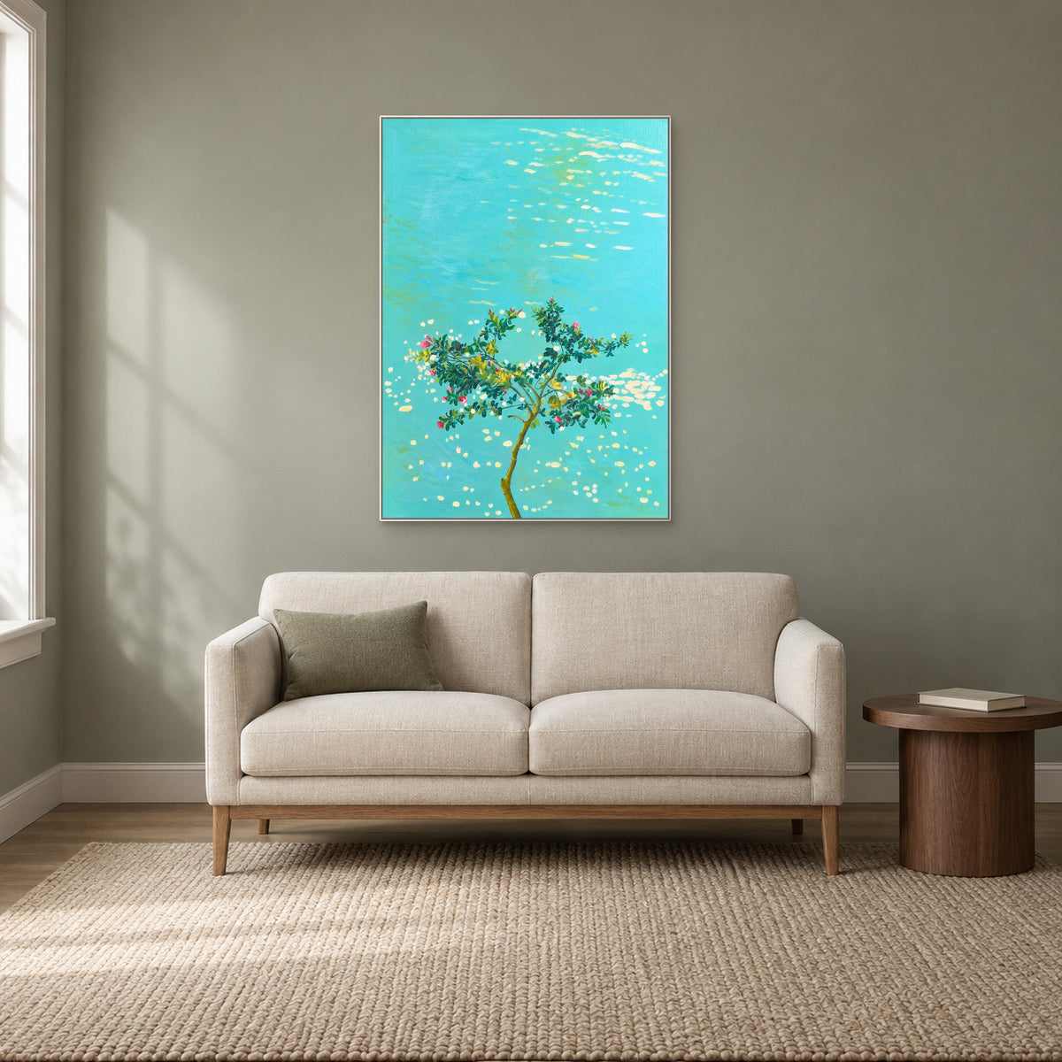 Fleurs sur l’eau turquoise dans un cadre flottant blanc au-dessus d’une petite banquette crème, sur un mur sauge