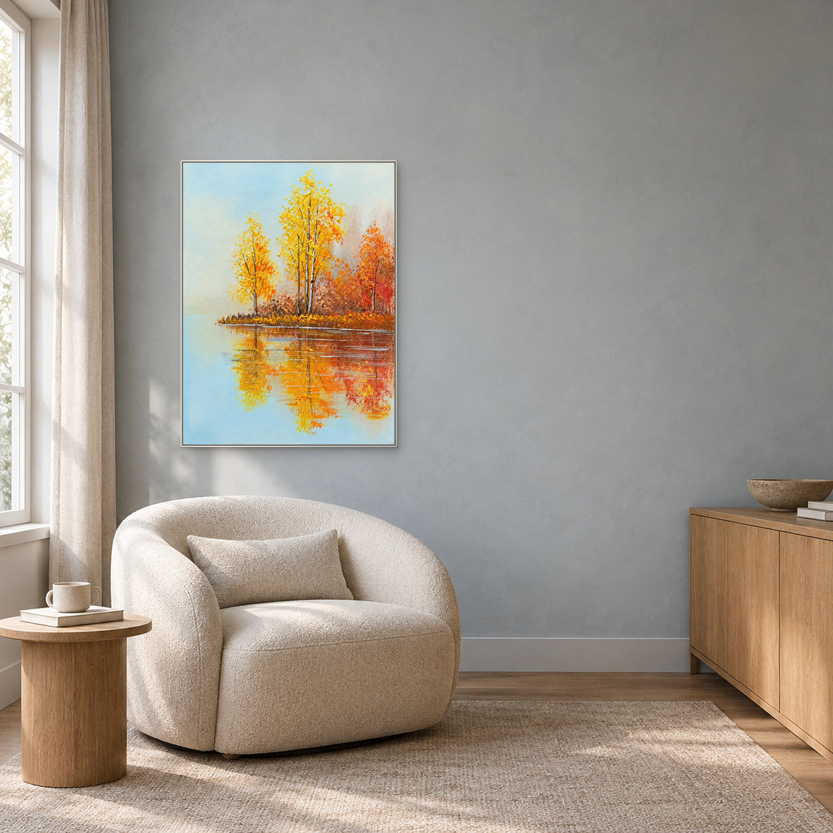 Autumn birch reflections in a white frame over a rounded cream reading chair against a grey wall