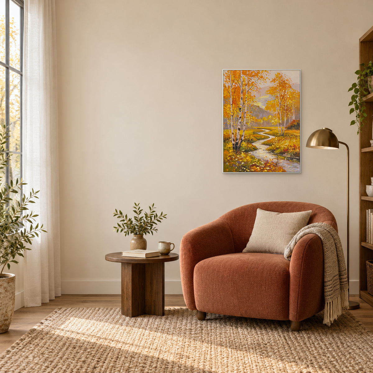 Golden woodland and stream painting in a white frame above a rust-coloured reading chair