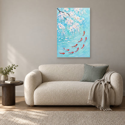 White blossoms and red koi on turquoise in a white floating frame above a cream boucle loveseat with a sea-glass cushion.