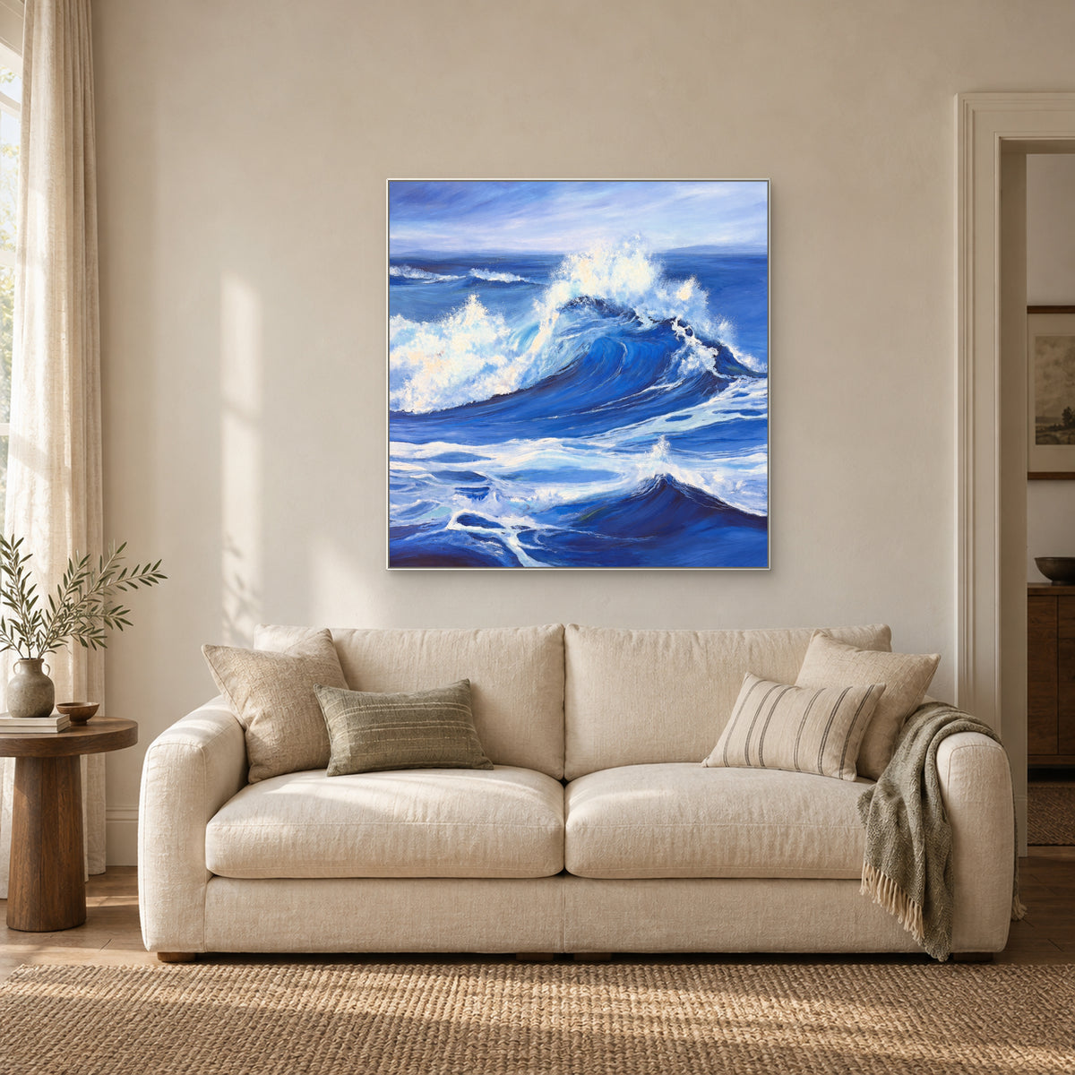 White-framed ocean wave painting above an ivory settee beside a sunlit curtain