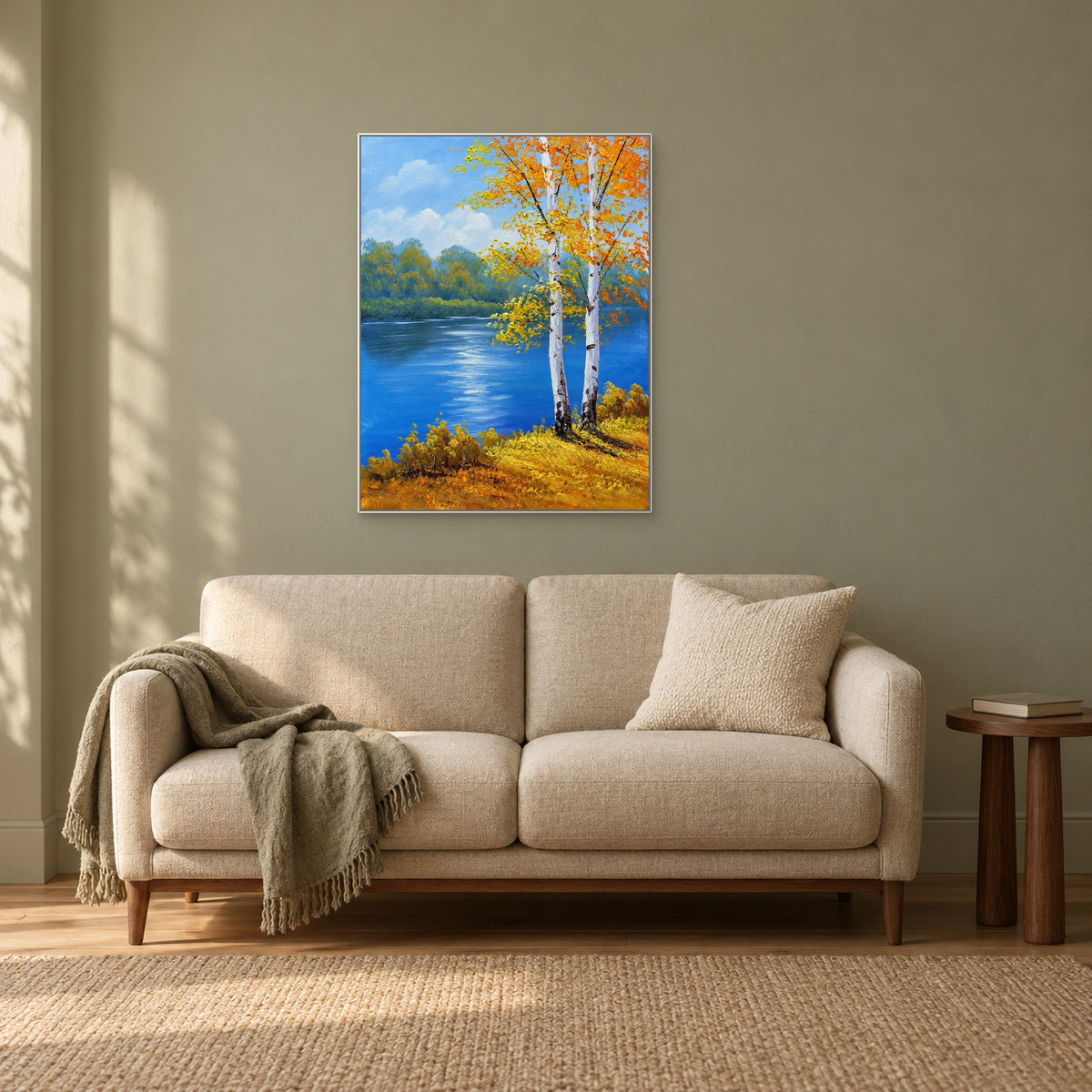 Autumn river landscape in a white frame above a cream settee beside a window