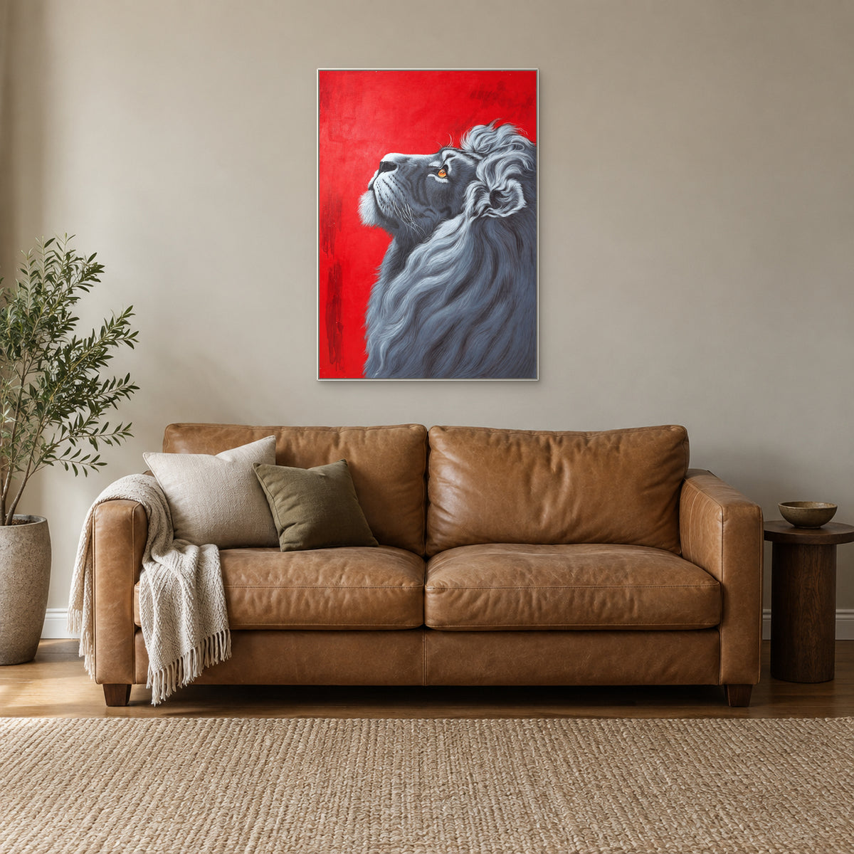 Vertical lion portrait on red in a white frame above a camel leather sofa