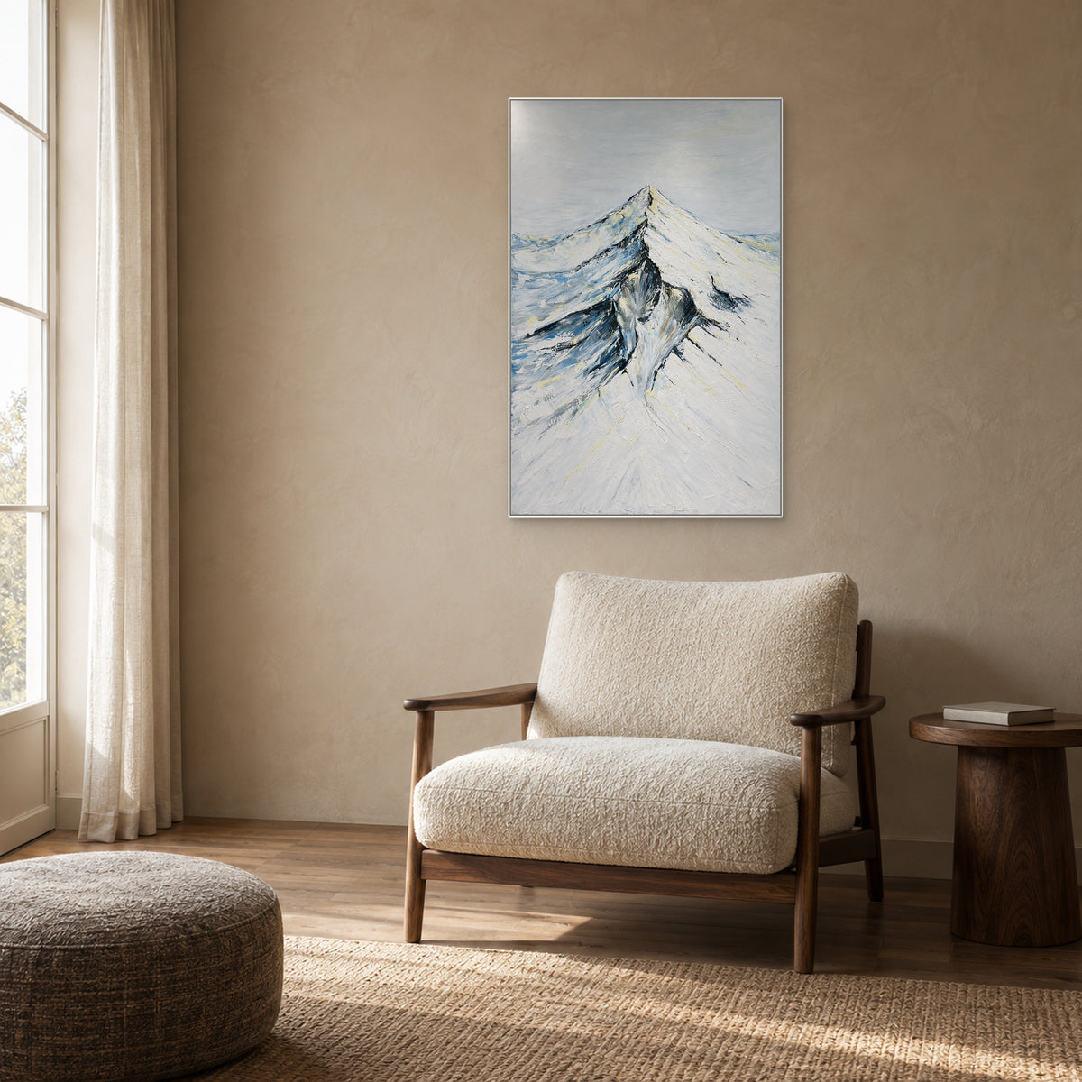 Ivory and blue-grey mountain painting in a white frame above a textured reading chair