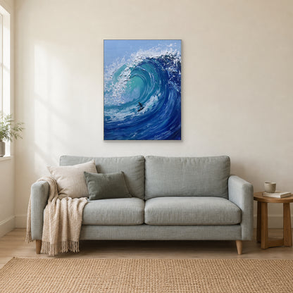White-framed barrel wave and surfer painting above a pale grey sofa beside a sunlit window