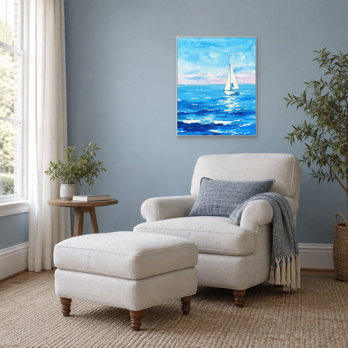 Vertical blue seascape in a white frame above an ivory reading chair, with soft window light.