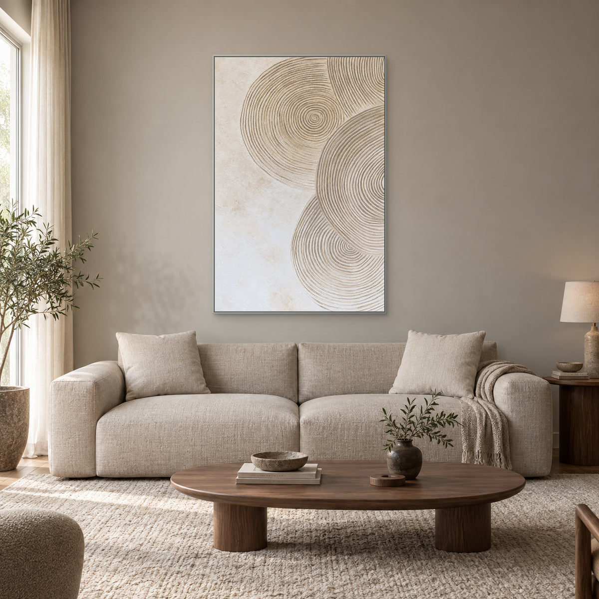 Vertical ivory ring relief in a silver-tone frame above an oatmeal sofa and an oval wooden coffee table.