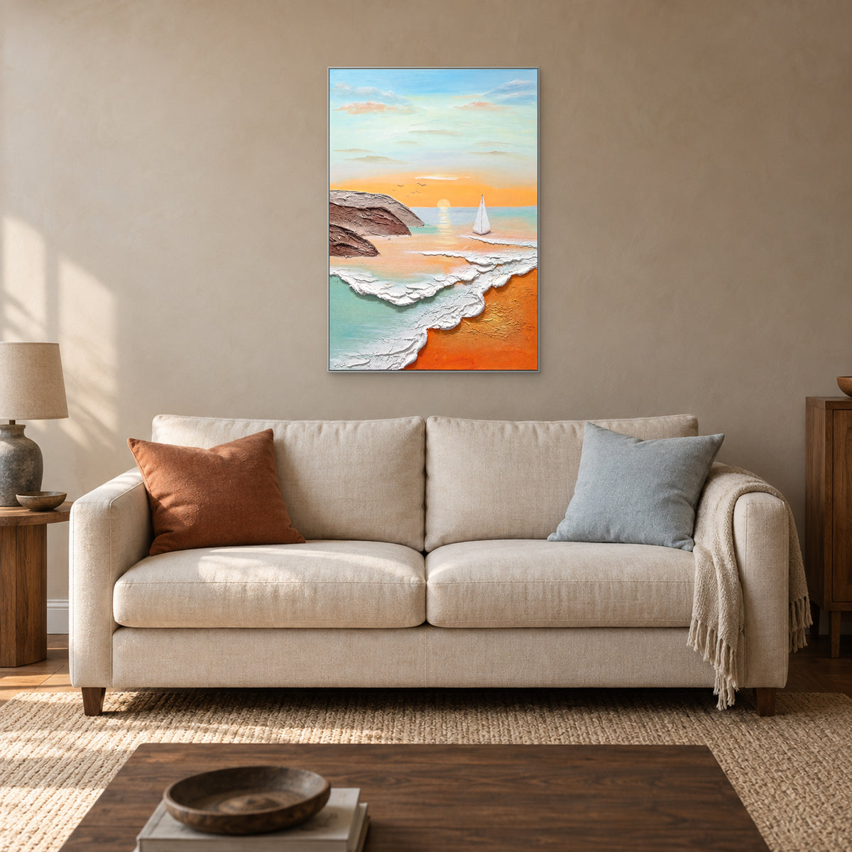 Apricot and turquoise seascape in a silver-tone frame above a cream sofa with rust and blue cushions