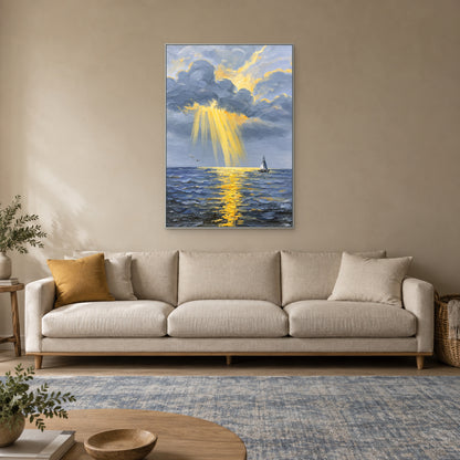 Vertical golden-light seascape in a silver-tone frame above a cream sofa.