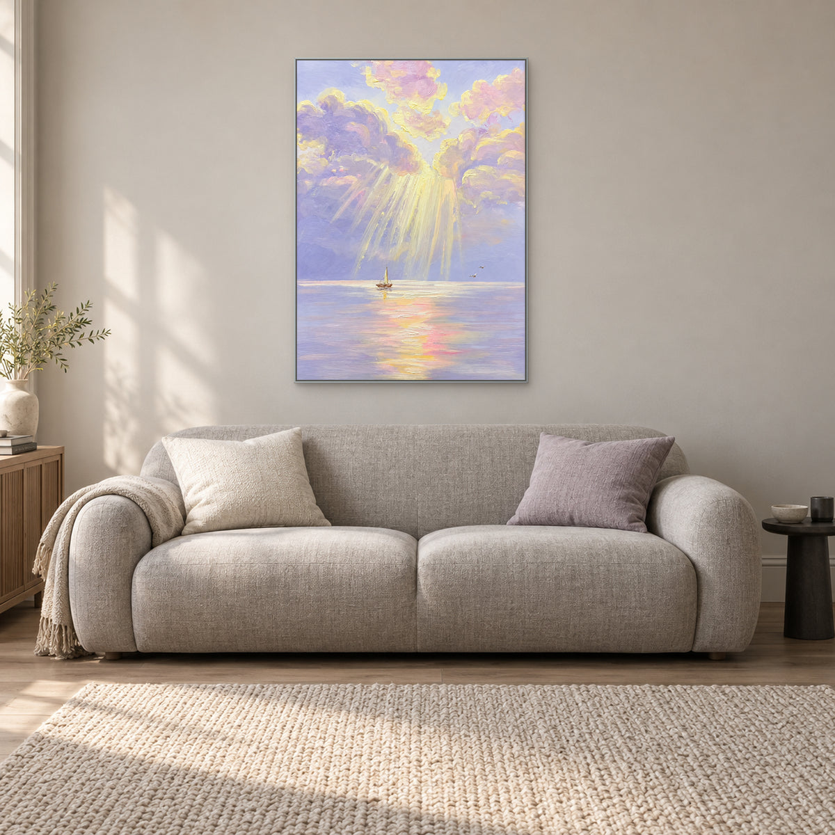 Cloud and sailboat painting in a silver-tone frame, centred above a light grey sofa with a lilac cushion.