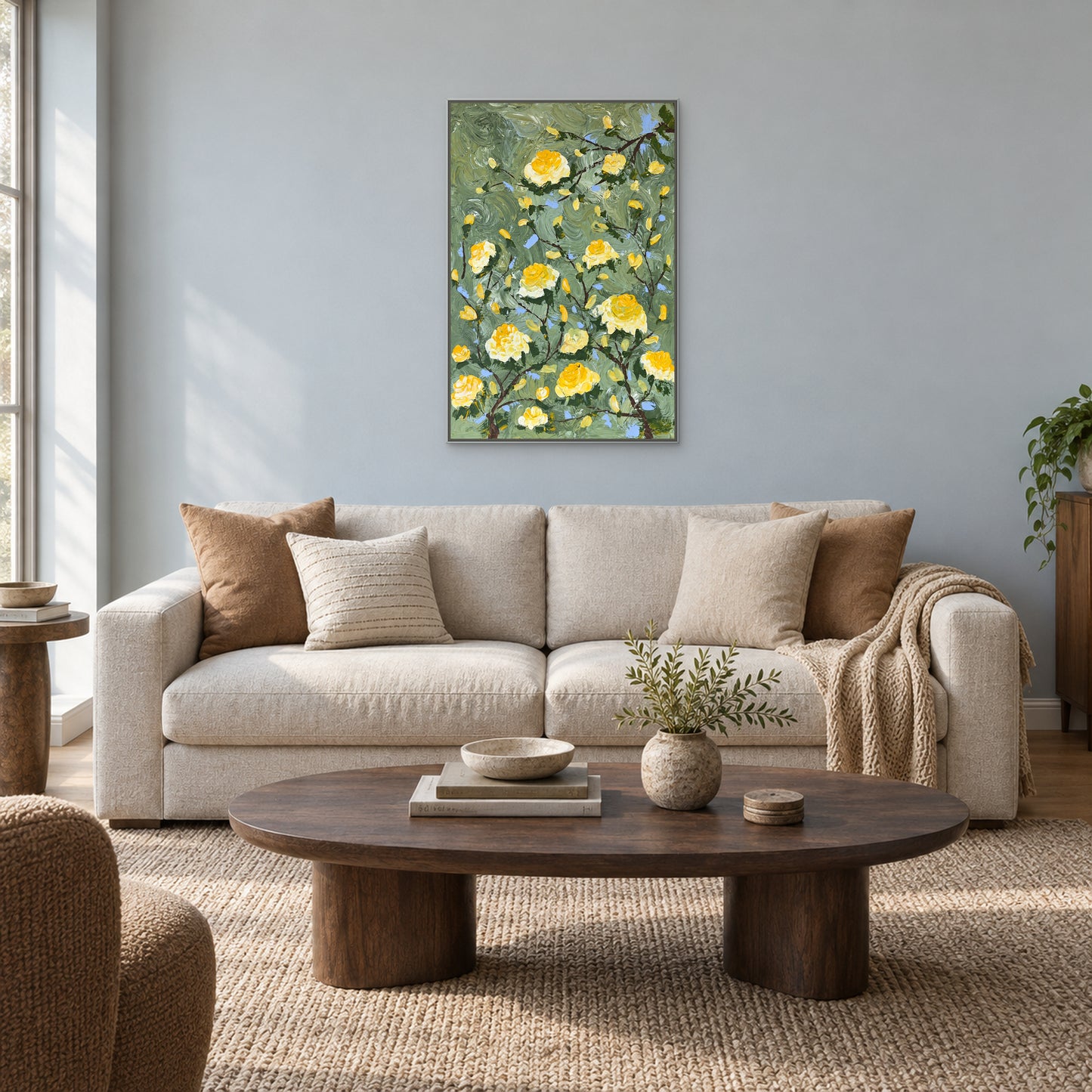 Vertical rose painting in a silver-tone floating frame above an oatmeal sofa on a pale blue-grey wall