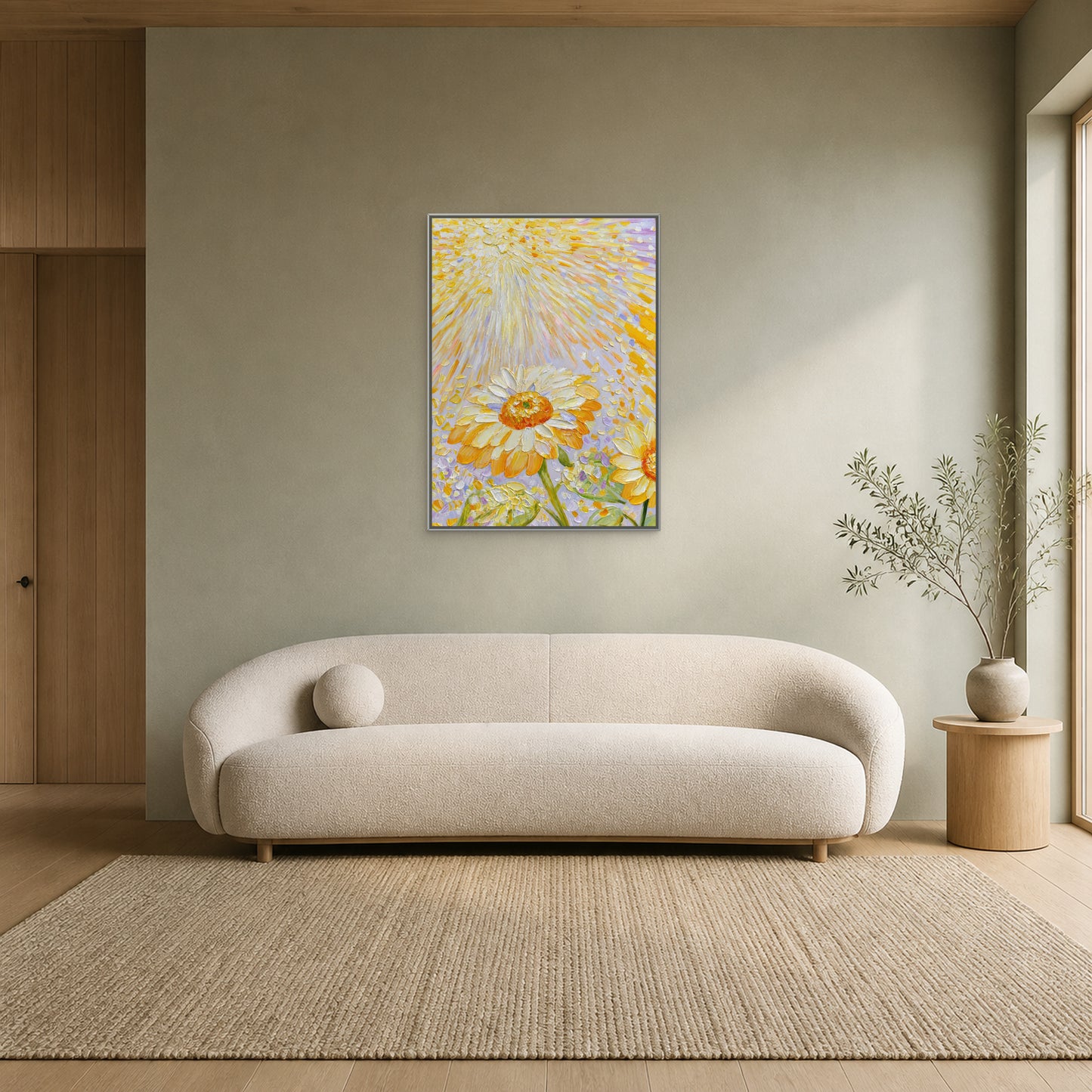Sunflowers in Golden Light in a slim silver floating frame centred above a curved cream sofa on a pale sage wall