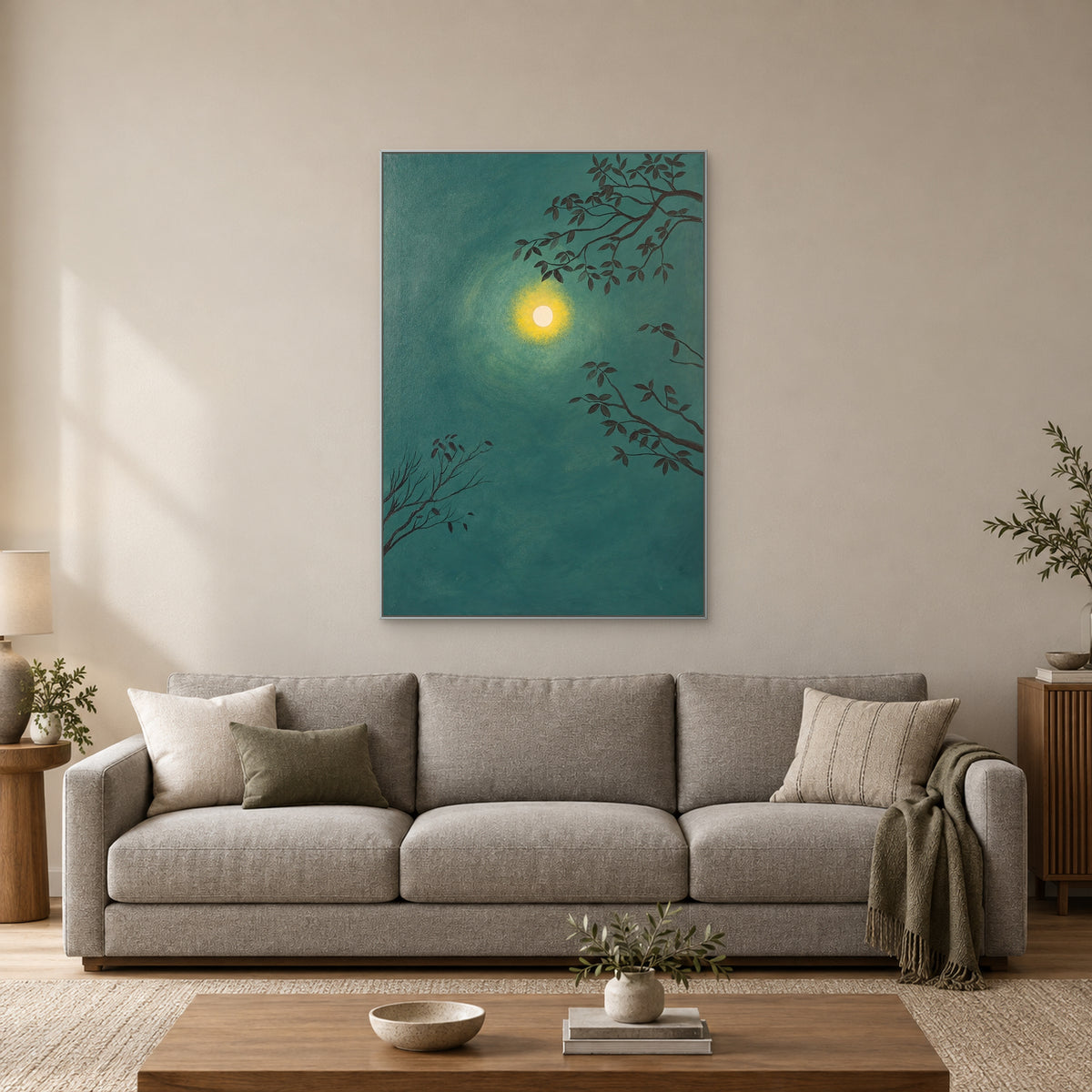 Moon and branches wall art in a silver-tone frame above a grey sofa