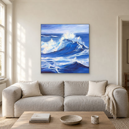 Silver-framed blue breaker and white spray above a grey linen sofa in a bright living room